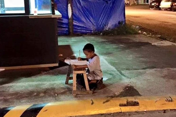 "歩道で勉強する少年"の画像に、世界中の人々の心が動かされている！