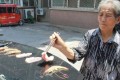 ちょっと何やってんの!? 猛暑日に車の上で肉やエビを焼く中国の女性がシュールだ