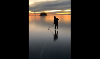まるで絵画のよう・・・夕日で染まる凍った湖とアイスホッケーをする子供のシルエットが幻想的!