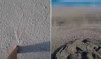 男性が泥沼を進んでいると思いきや、どうやらその泥らしきもので波までできている・・・。実はこれ、海岸まで打ち寄せた軽石だったのです