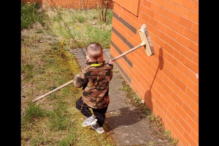 大きなブラシを持って歩く男の子。さあ、門を潜って外に出よう！としたその次の瞬間、新たな学びを得るハプニングが！！