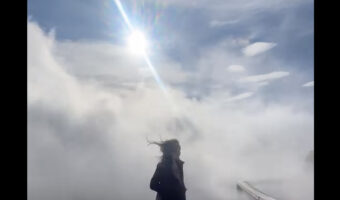 流れる雲の中で映える動画を撮ろうとした女性。ところが風が強すぎてハプニング映像に！【海外・動画】