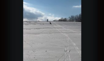 雪の積もった坂を下って来るのは・・。ソリじゃなくてエアマットに乗ったタンクトップにハーフパンツのお兄さん！？【アメリカ・動画】