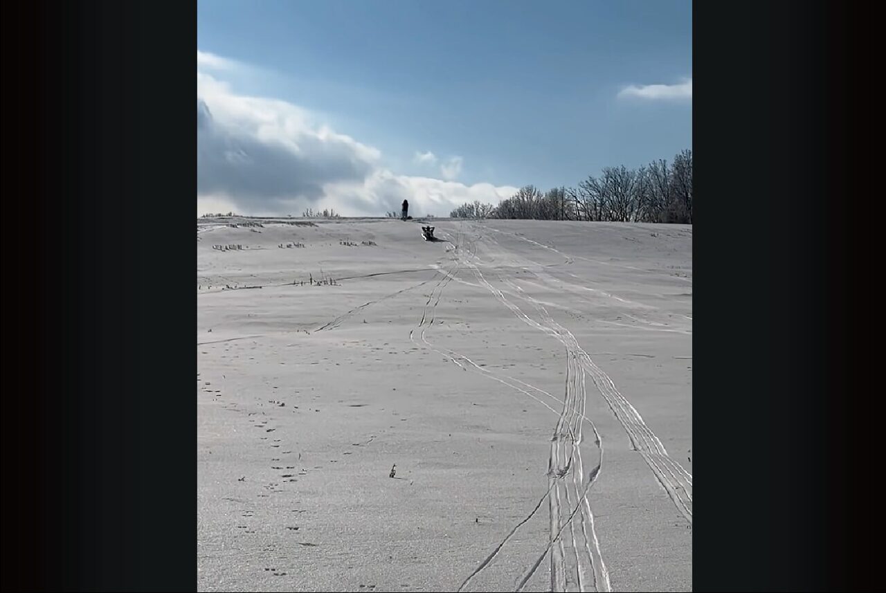 雪の積もった坂を下って来るのは・・。ソリじゃなくてエアマットに乗ったタンクトップにハーフパンツのお兄さん！？【アメリカ・動画】